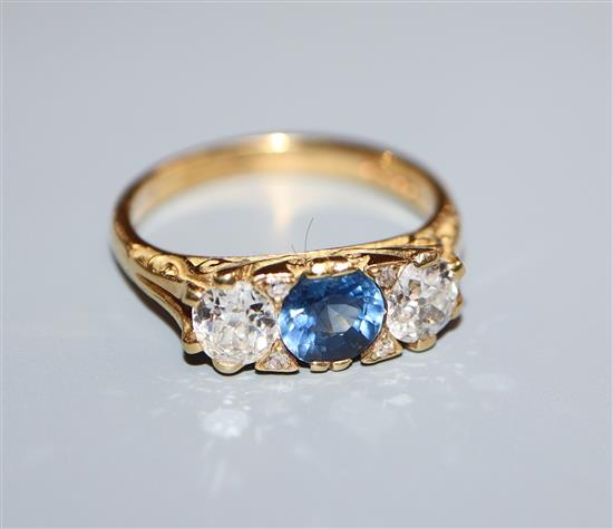 A 1970s Edwardian style 18ct gold, sapphire and diamond three stone ring, size N.